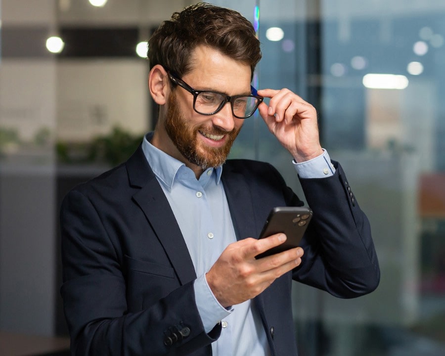 Man med glasögon läser på mobil om Accounting & Capital Markets Day 2025.