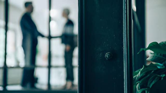 Kvinnliga kollegor sitter vid arbetsplatser på kontor.